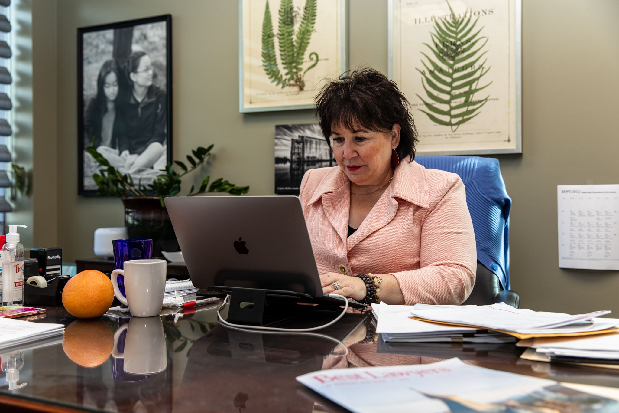 woman sitting at a desk with her laptop in front of her