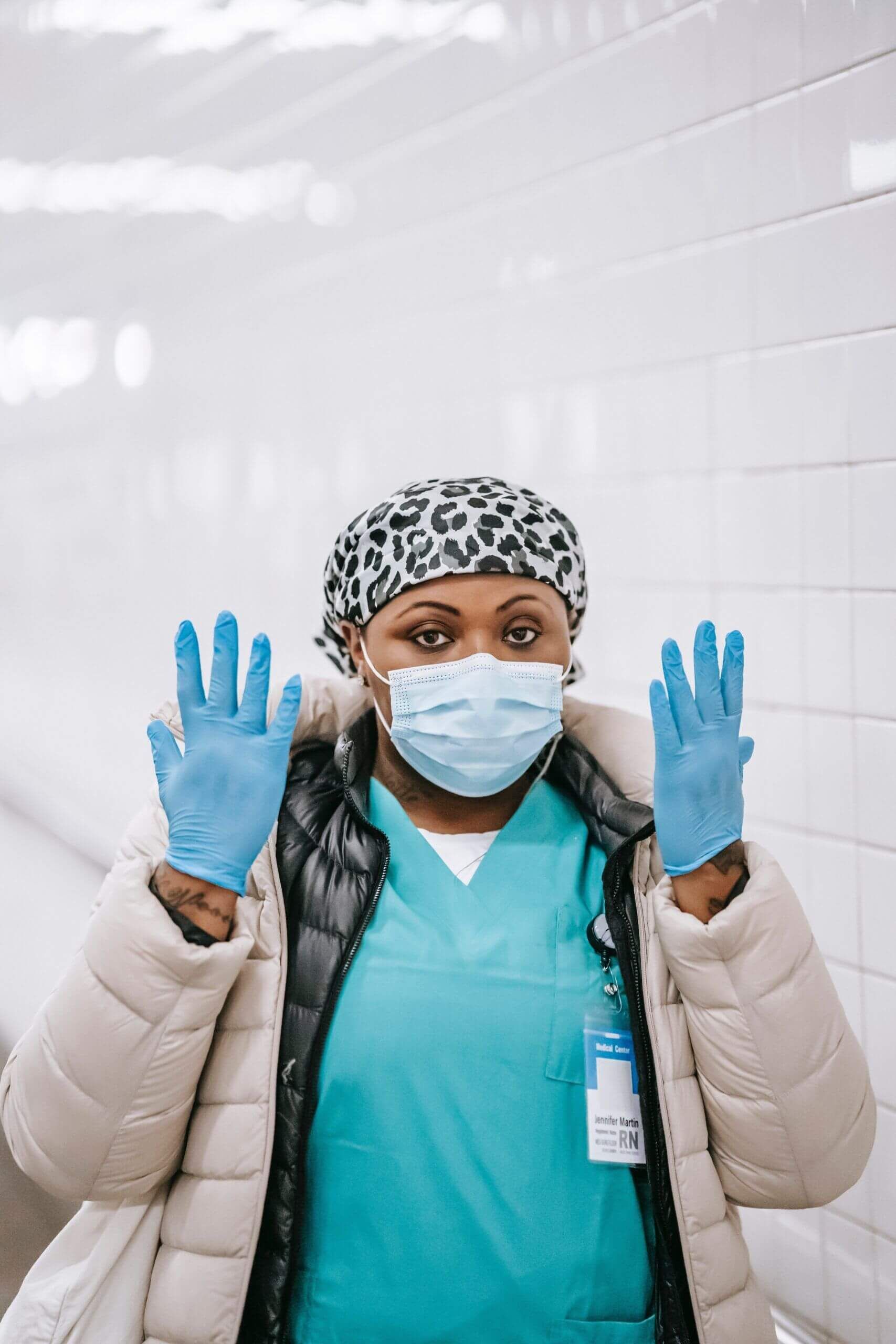 female medical worker holding up hands wearing gloves