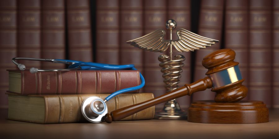 gavel and stethoscope on a table next to books