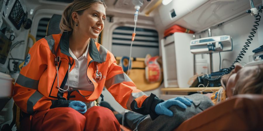 female EMS helping a man in an ambulance